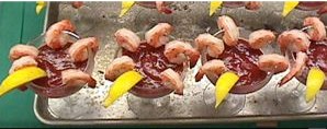Photo of a tray with shrimp cocktails garnished with a lemon slice.