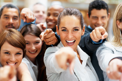 Happy group of employees all pointing at you