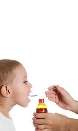 a child trying a spoonful of medicine