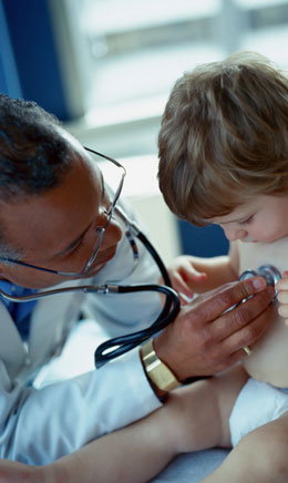 a doctor examines a small child with a stethoscope